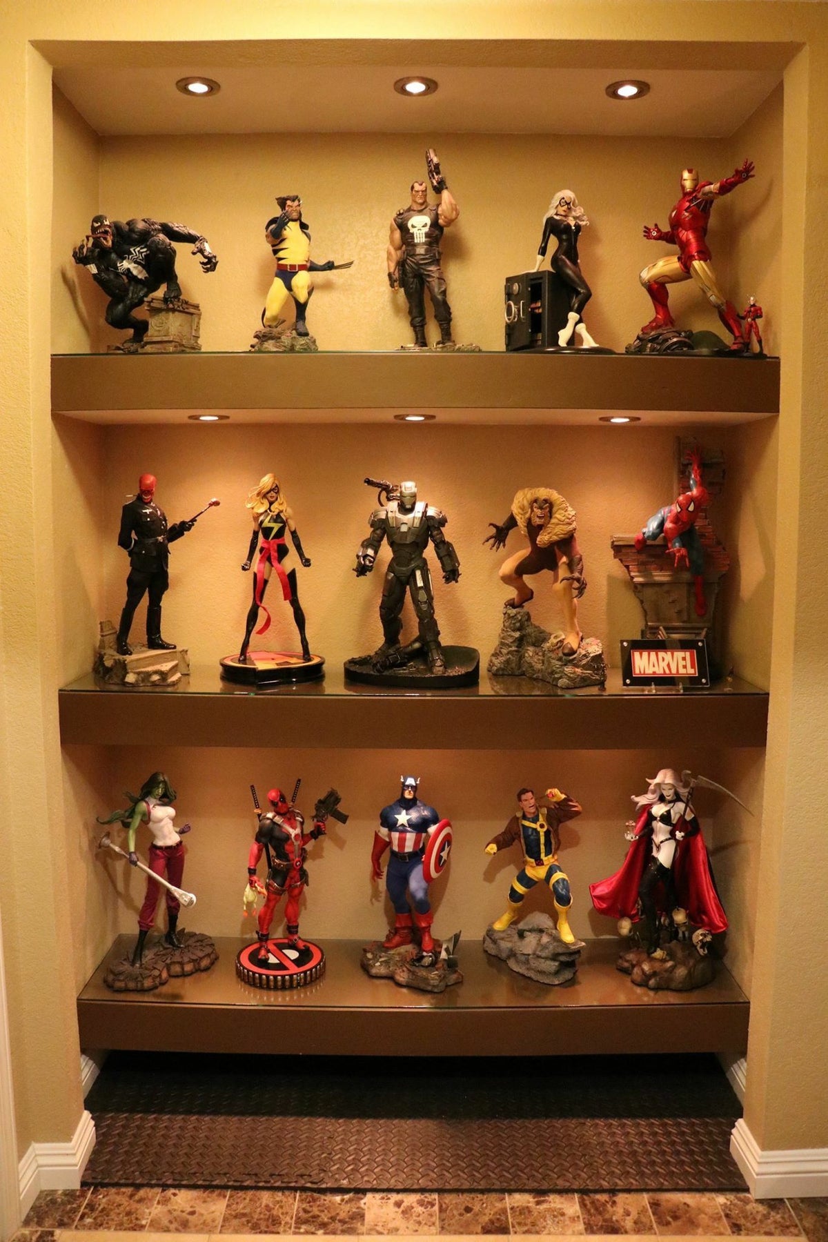 Estátuas de personagens Marvel expostas em prateleiras iluminadas